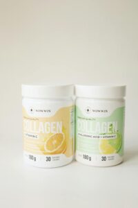 Photo of two collagen supplement jars with Vitamin C on a neutral background.